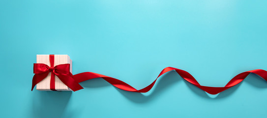  gift box with red bow on a blue background . Happy Father's or Mother's or Women 's  day...