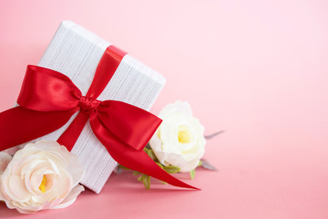  gift box with red bow on a pink background . valentine 's or Mother's or Women 's  day celebration concept