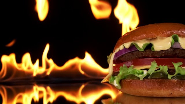 Close-up of a Burger with a fire background. Copy space, Slow motion.