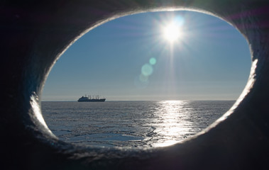 Morning in the Sea of Okhotsk, ship on the horizon, in the sea ice