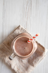 Top view, Homemade New England Chocolate Milkshake in a Glass Jar Mug on a white wooden background. Overhead, from above, flat lay. Copy space.