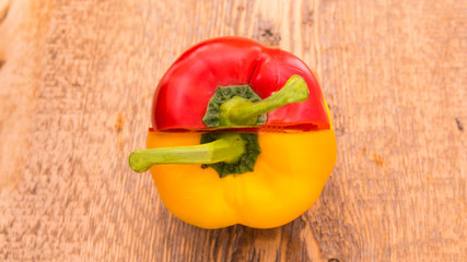 Red and yellow pepper on a wooden board, copy the space