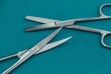 Basic surgical instrument stainless steel operation scissors curve s/s and Straight b/b isolated on surgical green drape fabric