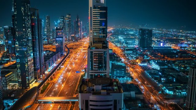 Timelapse of beautiful night Dubai skyline downtown, United Arab Emirates. Aerial view from above of highways with car traffic and skyscrapers buildings