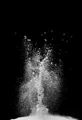 White powder explosion cloud against black background.White dust particles splash