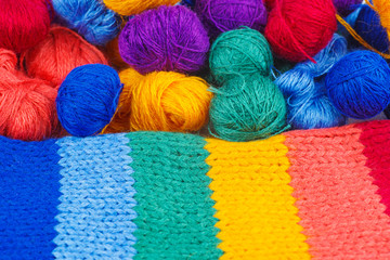 Rainbow knitted fabric and balls of wool thread
