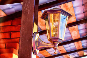 Streetlight on yellow wooden gazebo on a Sunny winter day with blue sky