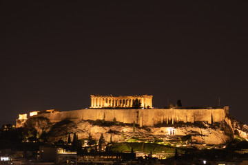 Night view of acropolis building on a hill with lights and beautiful scenery in Athens Greece