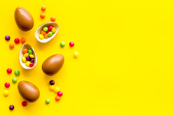 Chocolate eggs - Easter symbol - frame on yellow background top-down copy space
