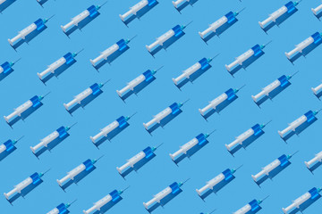 Health-care pattern of disposable syringes with blue liquid.