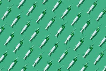 Medicinal pattern from syringes with green drugs or vaccine.