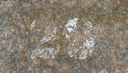 Faded and weathered number twenty nine painted on a rough street surface outdoors image in horizontal format with copy space