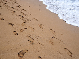Fototapeta na wymiar Footsteps footprints on the beach sand