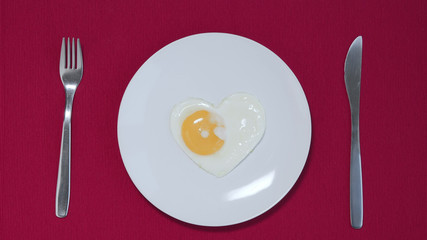 Plain white plate with heart formed egg. Valentine's concept Top view