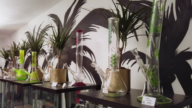 Lab glass bongs with green leaves displayed and available for sale in CBD shop - medium shop