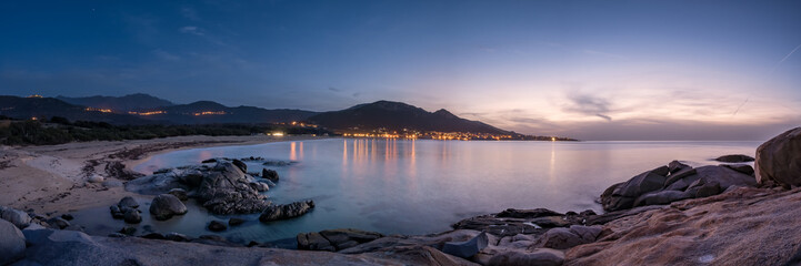 Night falling over beach and village of Algajola in Corsica