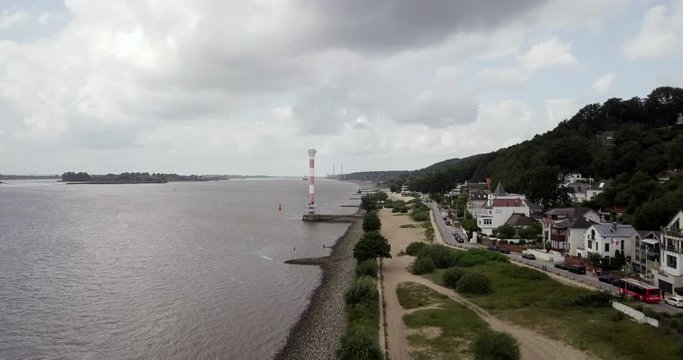 A stunning red and white summer lighthouse built along the coast in Hamburg, Germany - Wide shot