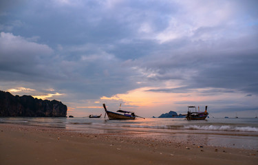 Traditional long-tail boat on the beach in Thailand at sunset