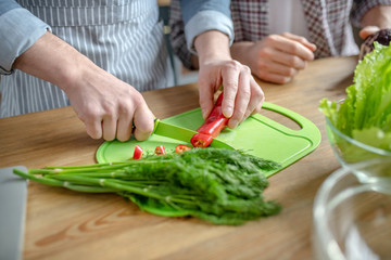 Close up picture of males hands cutting vegetables