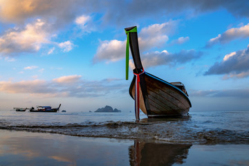 Traditional long-tail boat on the beach in Thailand at sunset