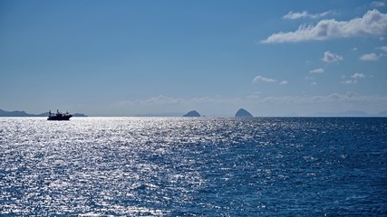 光を浴びて輝く海とイカ釣り船のコラボ情景＠長崎