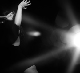  girl dancing in the light of a lantern on a black background