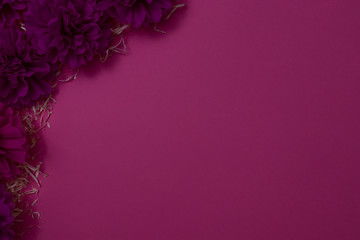 Artificial flowers on a pink background. Place for text. View from above. Flat lay.