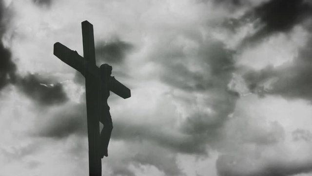 Jesus Christ crucified at Golgotha hill outside ancient Jerusalem. The Crucifixion of Christ with Stormy clouds time lapse. Vintage film look