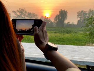 Woman take a photo by mobile phone on blurred landscape view background