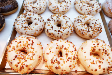 White donuts with chocolate chips on a tray