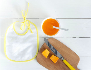 Bib, baby puree, spoon, Apple. The view from the top, flat lay.The concept of healthy nutrition for...