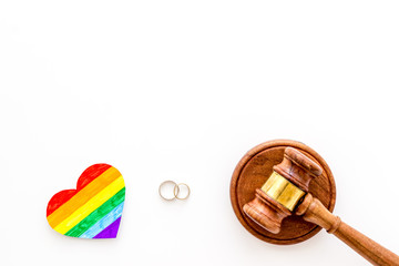 LGBT divorce. Rainbow heart near rings and judge gavel on white background top-down copy space