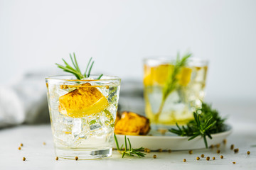 Glasses of Gin and Tonic with Charred Lemon, Rosemary and Coriander is a flavors are perfectly balanced refreshing cocktail. on light background, close up surrounded ingredients, selective focus - obrazy, fototapety, plakaty