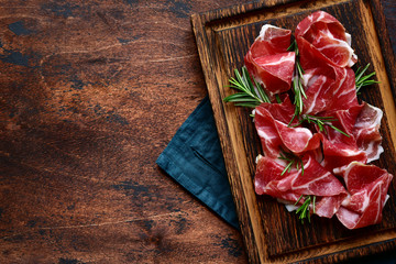 Slices of prosciutto di parma or jamon serrano (iberico) . Top view with copy space. - obrazy, fototapety, plakaty