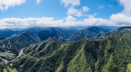 Naklejka na ściany i meble Drone Aerial Panorama of mountains and rice fields and blue sky / agricultural landscape asia