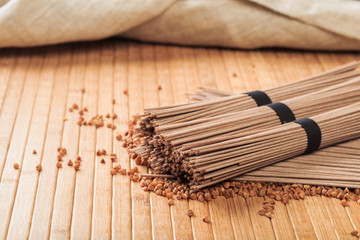 Fototapeta na wymiar Buckwheat noodles closeup. Raw food ingredient. Dried buckwheat soba noodles. Traditional Japanese food - Image
