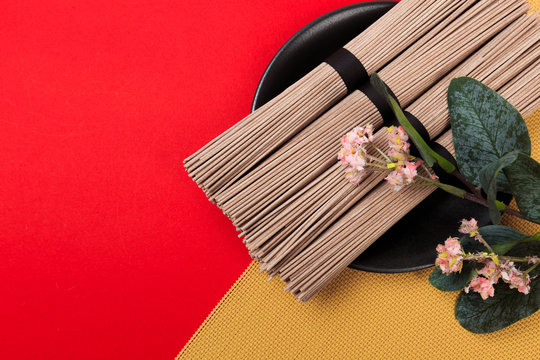 Dried Organic Buckwheat Soba Noodles Ready to Cook on red background  - Image