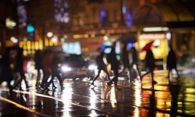 crow of people walking gin the city on rainy night