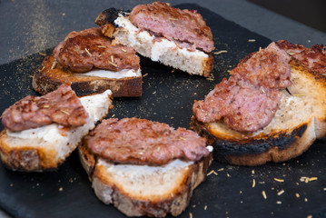 Grilled sausages with bread on black plate