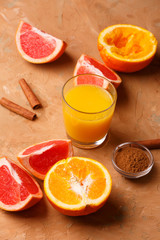 Organic foods orange, grapefruit, juice and aromatic cinnamon. Brown background.
