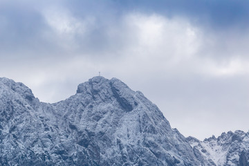 Fototapeta na wymiar Giewont Mountain in polish Tatra Mountains covered with snow under cloudy sky