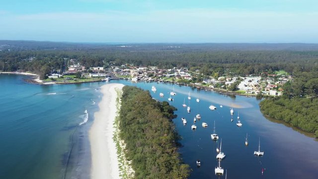 Aerial drone view of Huskisson on the New South Wales South Coast, Australia, showing Currambene Creek and Jervis Bay on a bright sunny day   