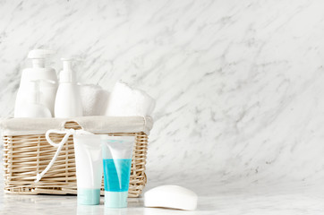 Basket with body care accessories on marble background. 