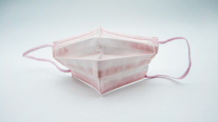 Close-up of medical mask pink on a white background. A disposable masks