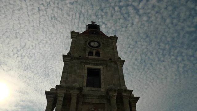 Low angle view of the Medieval Clock Tower Roloi with cirrocumulus clouds around, Old Town of Rhodes, Greece