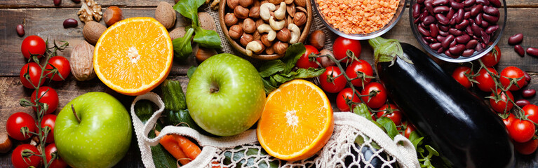 Concept of healthy vegan food, clean eating. Fresh raw ingredients on wooden background: vegerables, fruits, nuts, beans and lentils. No plastic, eco-friendly shopping for zero waste. Banner