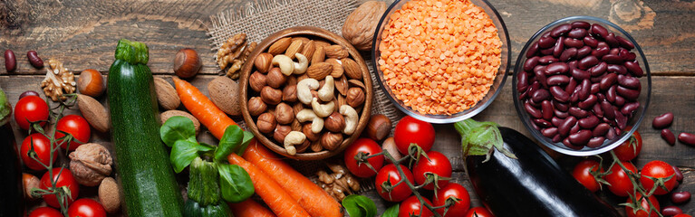 Concept of healthy vegan food, clean eating. Fresh raw ingredients,  wooden background: vegetables, nuts, beans, lentils. Ripe colorful seasonal product for clean meal. Banner