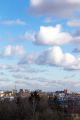 Urban landscape with beautiful sky in clouds in early spring in Europe. View of the city from a tall building. Vertical.