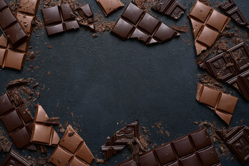Slices of dark and milk chocolate. Top view with copy space. - obrazy, fototapety, plakaty
