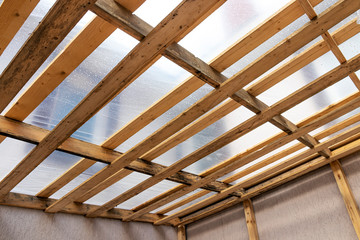 Flat roof rafters covered with a plastic sheeting from the rain